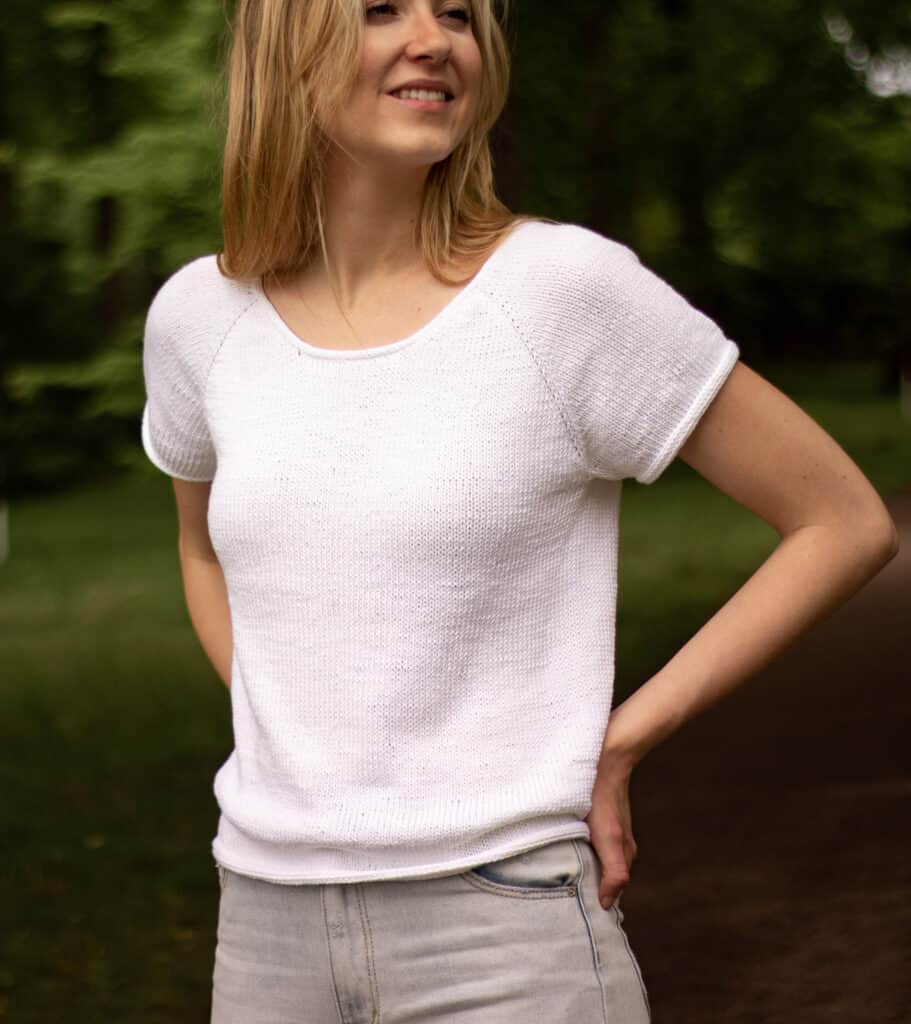 knit t-shirt detail image showing neckline on model with hands on hips