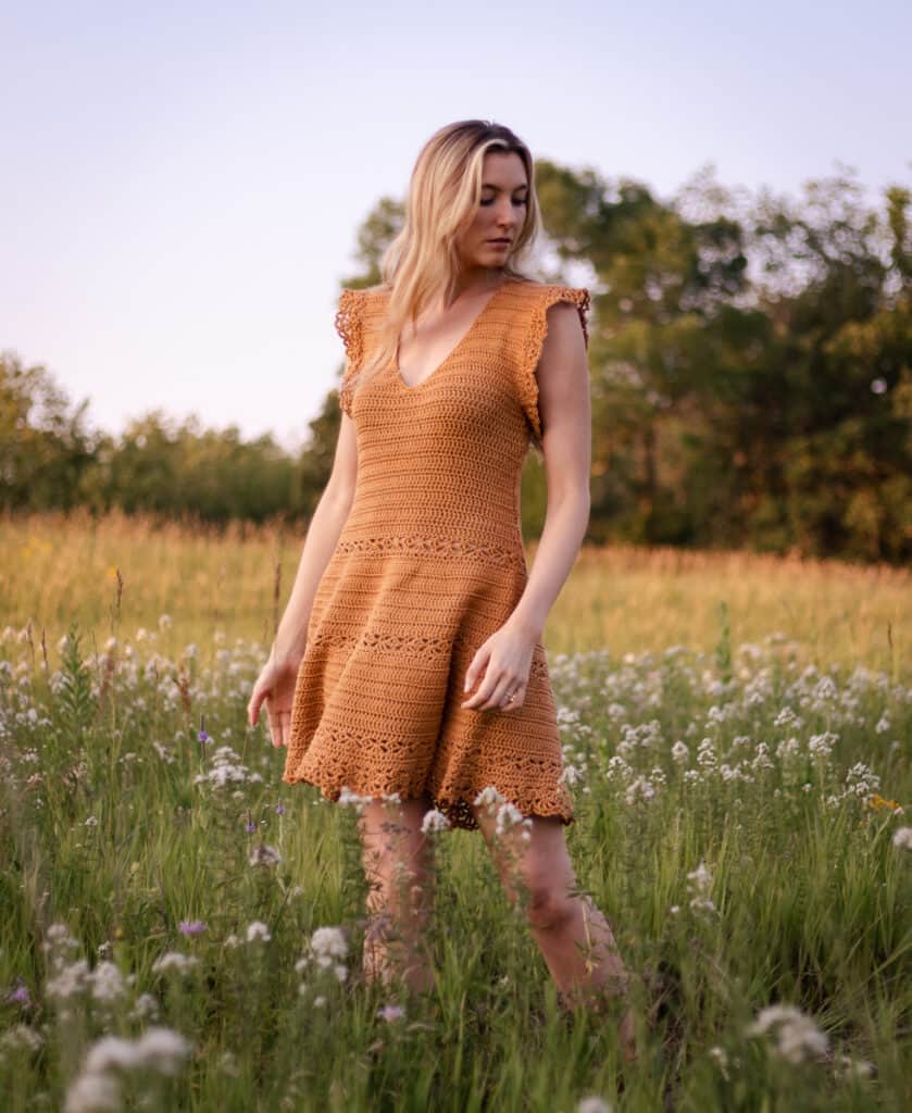 Dress being worn in a flower field on a model who is twirling so the skirt is in motion