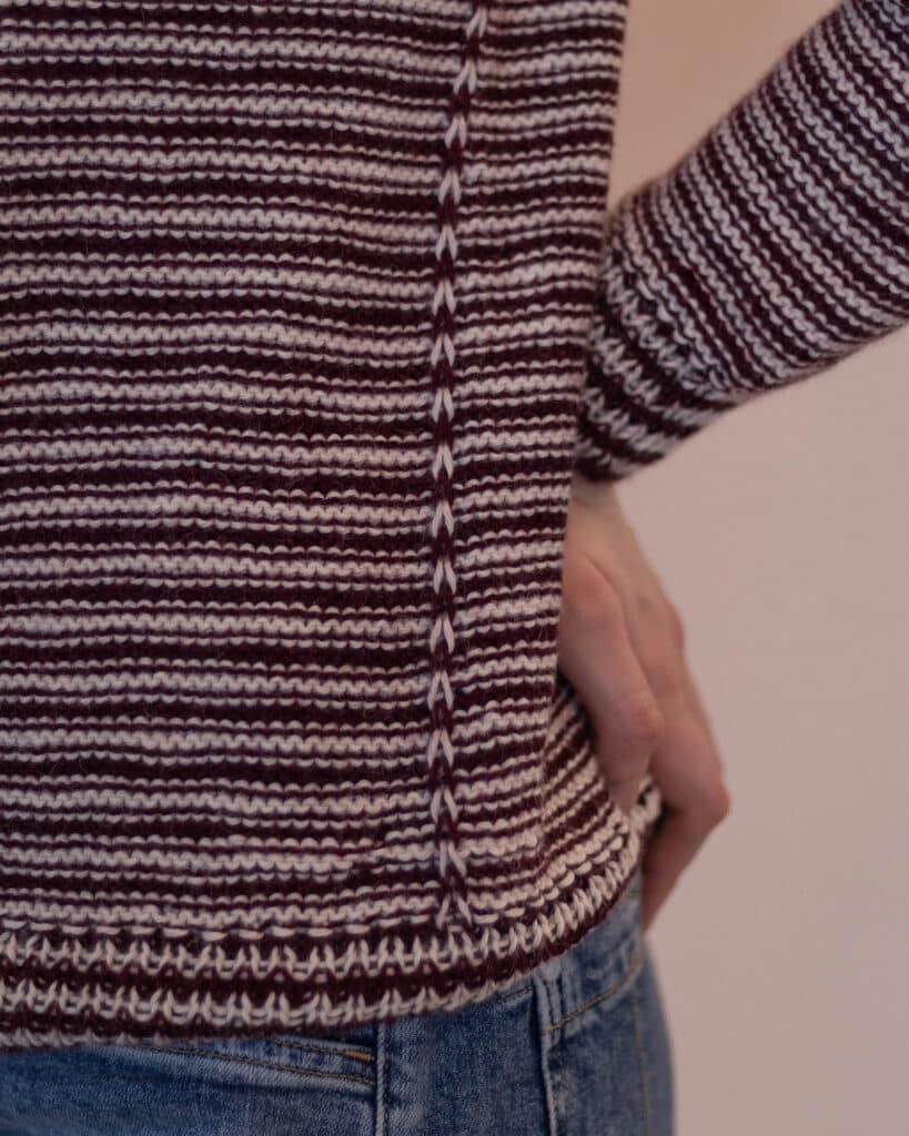 Detail image of the slipped stitch faux seams that are knit into the seasons sweater knitting pattern along the side of the body